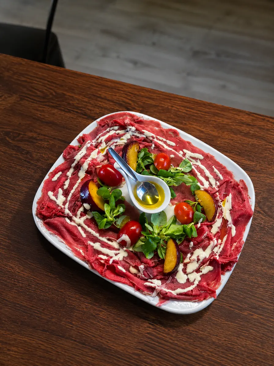 Carpaccio di manzo con pomodorini, songino e olio extravergine